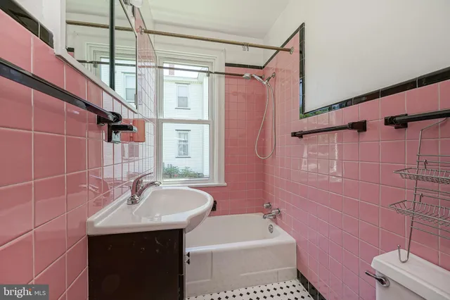 a bathroom with a sink a toilet a mirror and shower