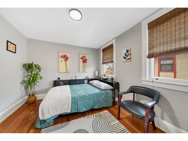 a bedroom with a bed and a dresser next to a window