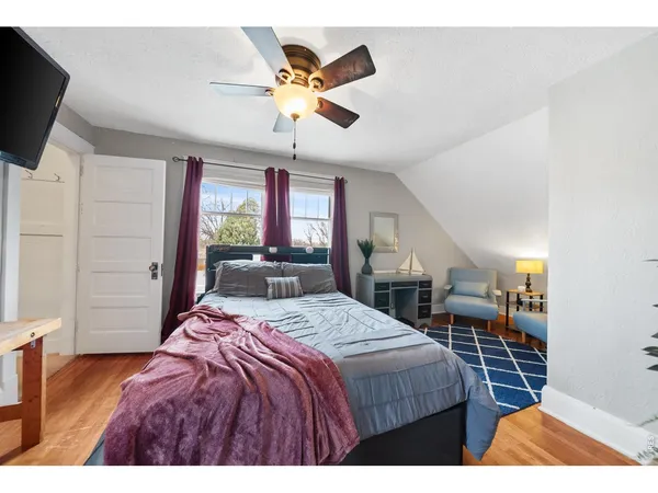 a bedroom with a bed a flat screen tv and dresser