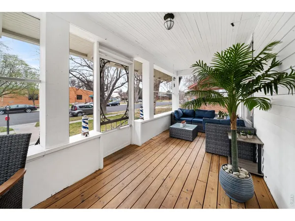 a living room with furniture floor to ceiling window and wooden floor