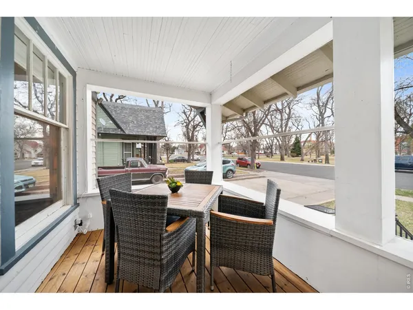 a dining room with furniture large windows and wooden floor