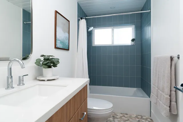 a bathroom with a sink a toilet a tub and shower