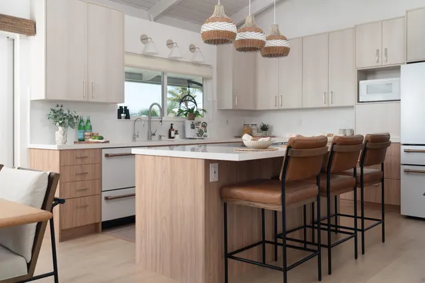 a kitchen with stainless steel appliances kitchen island granite countertop a table chairs in it and white cabinets