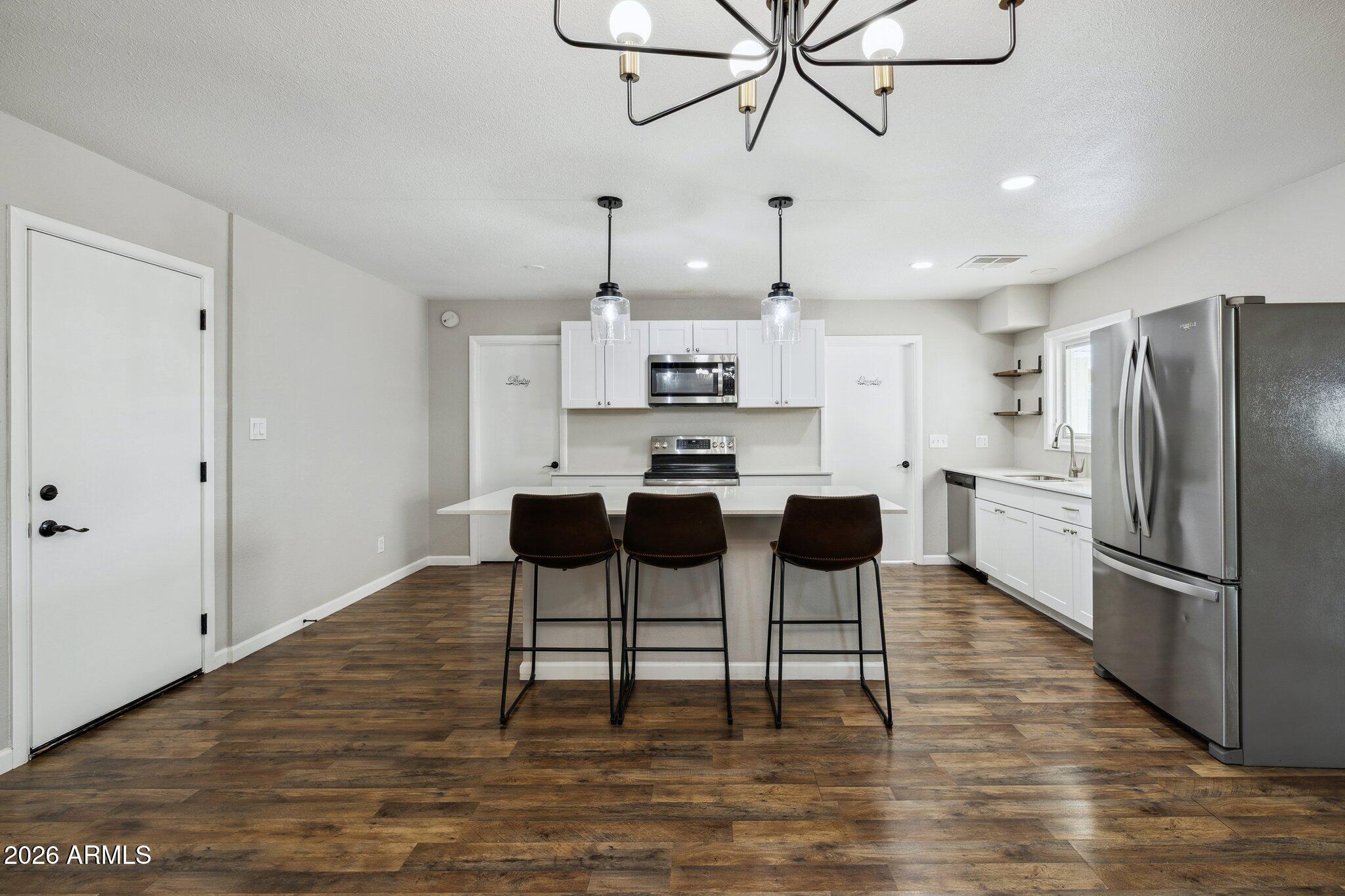 13002 North 28th Place Phoenix, AZ 85032 - Photo 10 of 42 a kitchen with stainless steel appliances kitchen island a refrigerator and microwave
