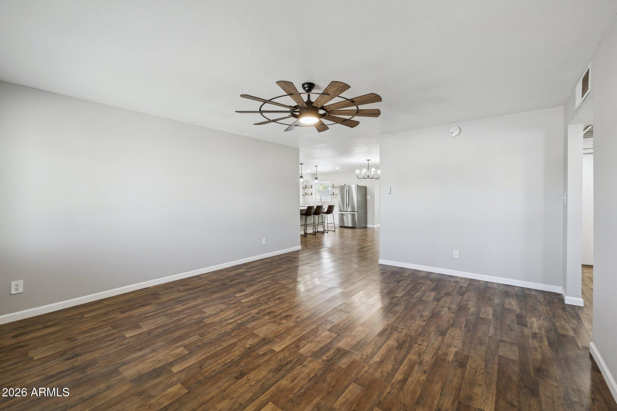 13002 North 28th Place Phoenix, AZ 85032 - Photo 12 of 42 a view of a room with wooden floor and a ceiling fan