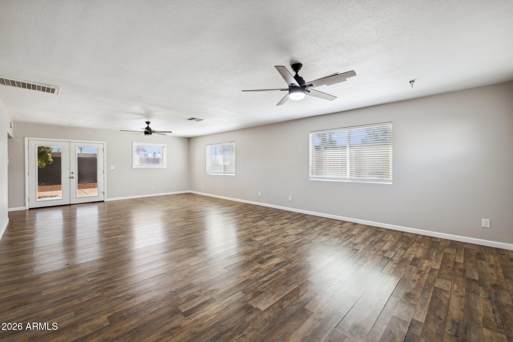 13002 North 28th Place Phoenix, AZ 85032 - Photo 18 of 42 a view of empty room with wooden floor and fan