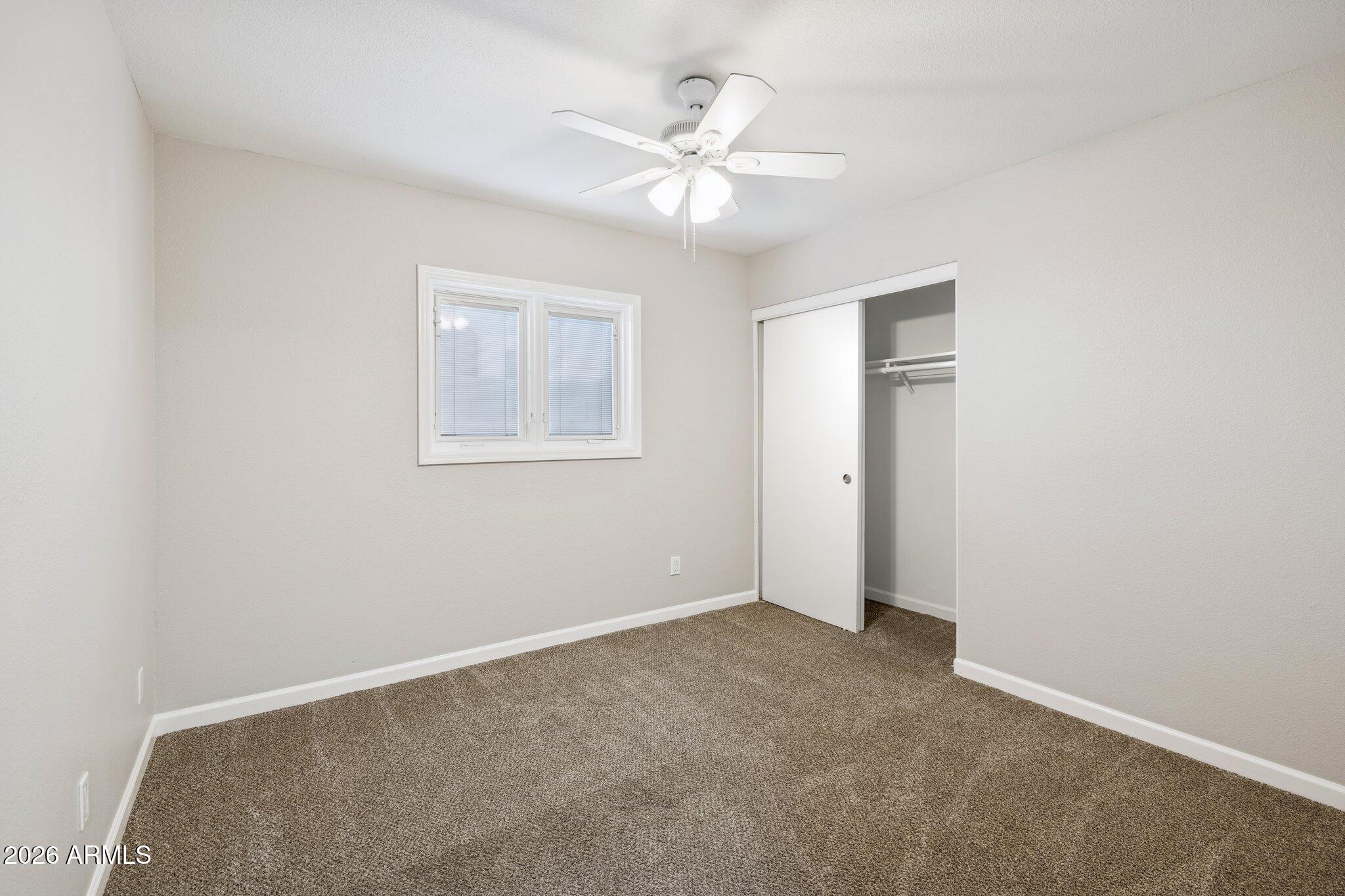 13002 North 28th Place Phoenix, AZ 85032 - Photo 24 of 42 an empty room with a fan and a window