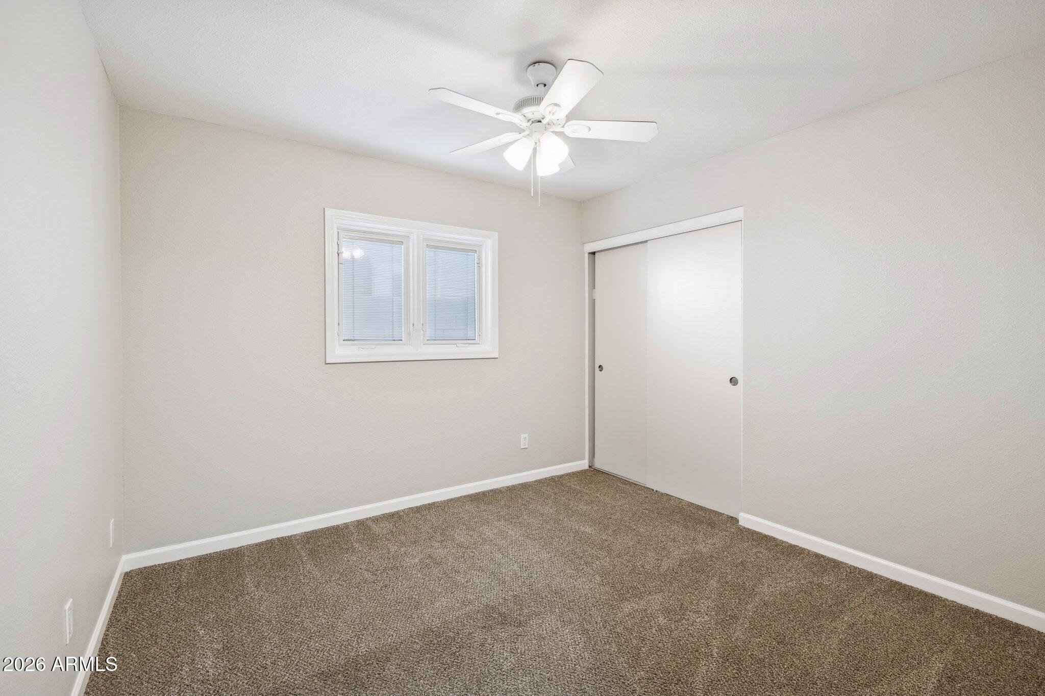 13002 North 28th Place Phoenix, AZ 85032 - Photo 25 of 42 an empty room with a fan and a window