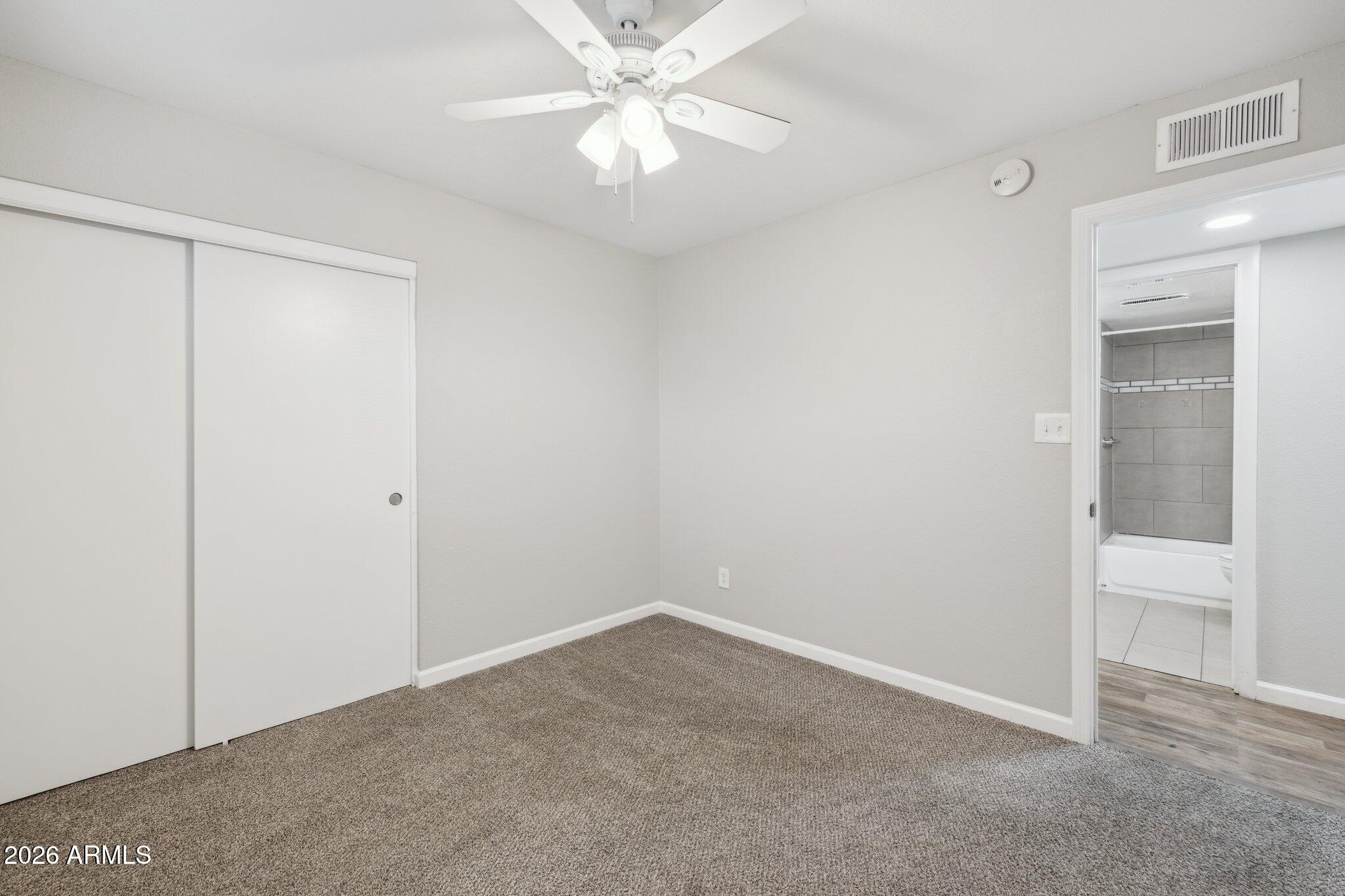 13002 North 28th Place Phoenix, AZ 85032 - Photo 26 of 42 an empty room with a ceiling fan and a window