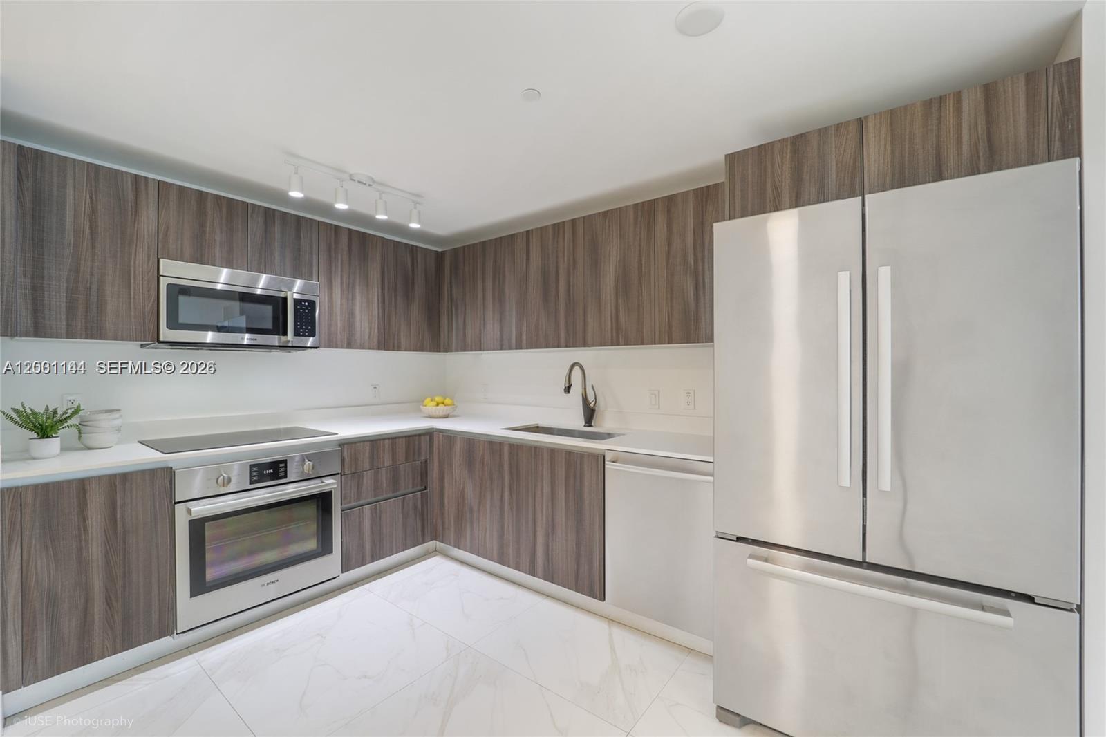 a kitchen with stainless steel appliances a refrigerator sink and microwave