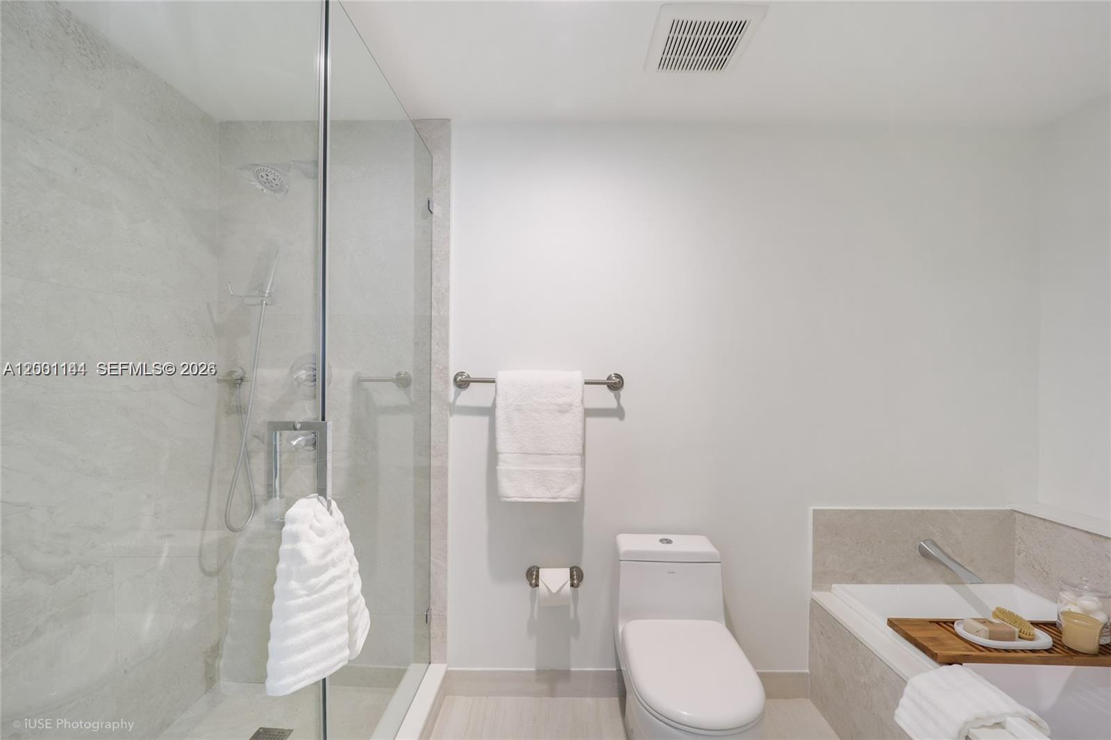 488 Northeast 18th Street, Unit 505 Miami, FL 33132 - Photo 8 of 12 a white toilet sitting next to a bathroom sink and a shower