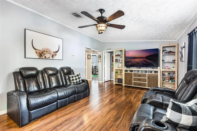 a living room with furniture ceiling fan and a window