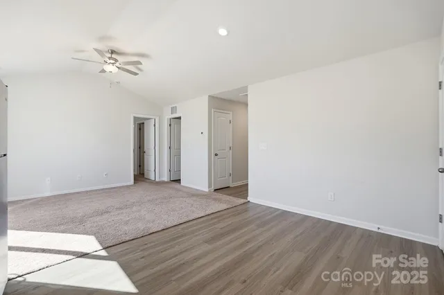 a view of a room with wooden floor and ceiling fan