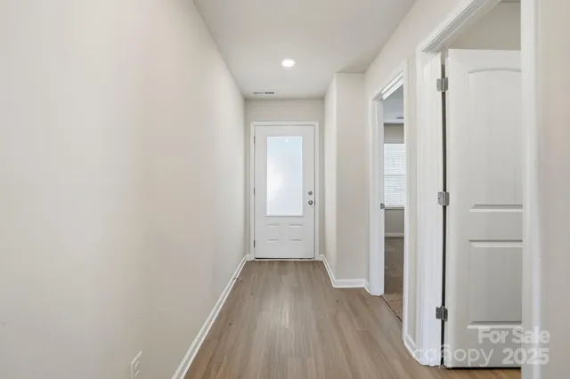 a view of a hallway with wooden floor