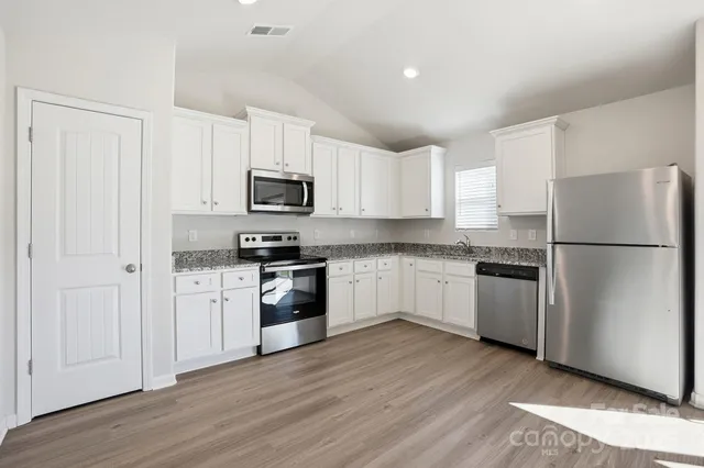 a kitchen with a refrigerator stove and wooden cabinets