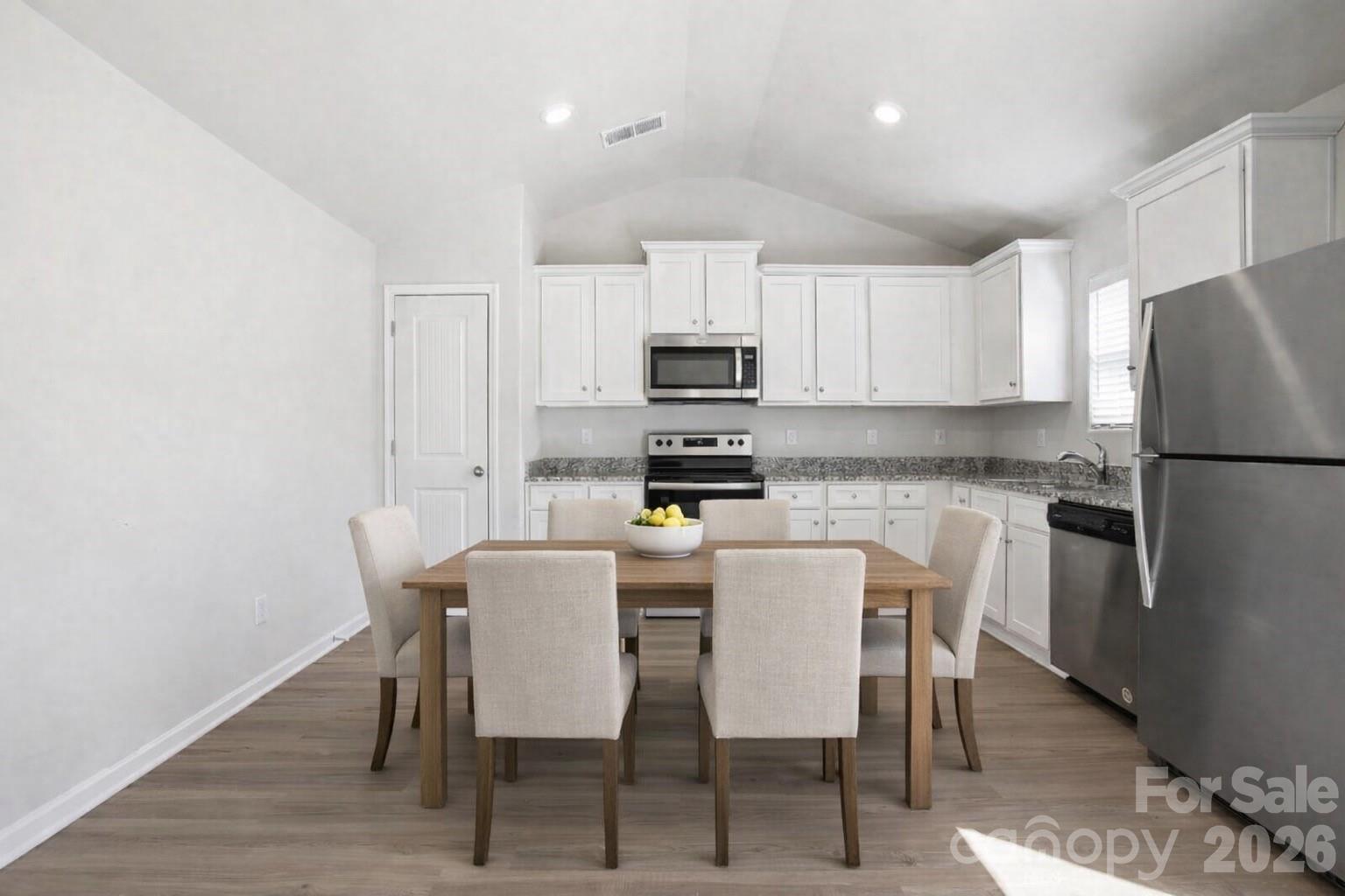 907 Morien Street Richburg, SC 29729 - Photo 10 of 28 a kitchen with stainless steel appliances a white table and chairs in it