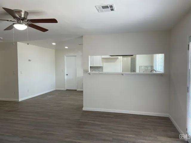 a view of empty room with wooden floor