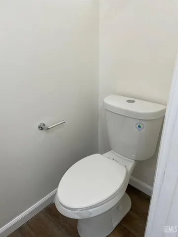 a white toilet sitting next to a white sink and vanity