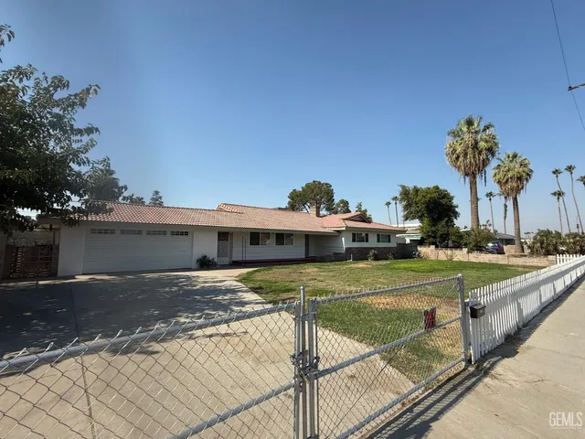 a view of a house with backyard and sitting area