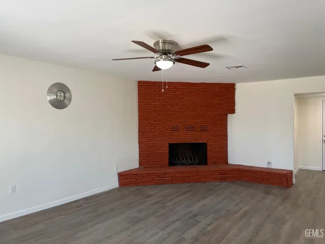 a view of empty room with wooden floor and fireplace