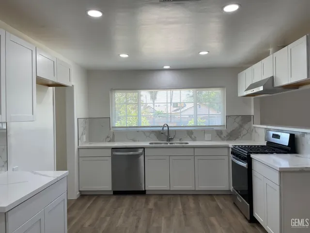 a kitchen with a sink stove cabinets and refrigerator