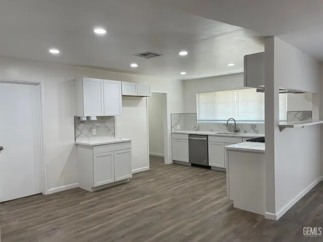a kitchen with white cabinets and white appliances