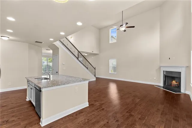 a kitchen with a sink chandelier and wooden floor