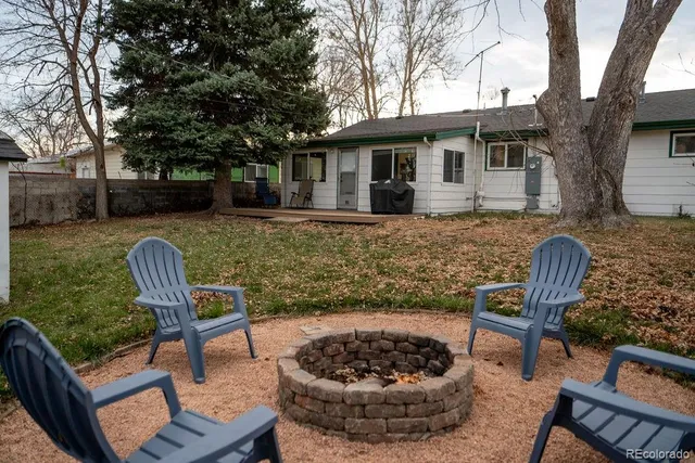 a view of a backyard with furniture and a fire pit