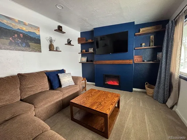 a living room with furniture a flat screen tv and a fireplace