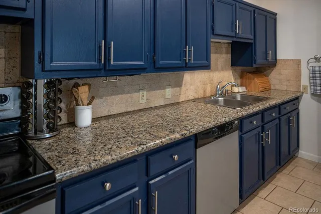 a kitchen with stainless steel appliances granite countertop a sink dishwasher stove and cabinets with wooden floor