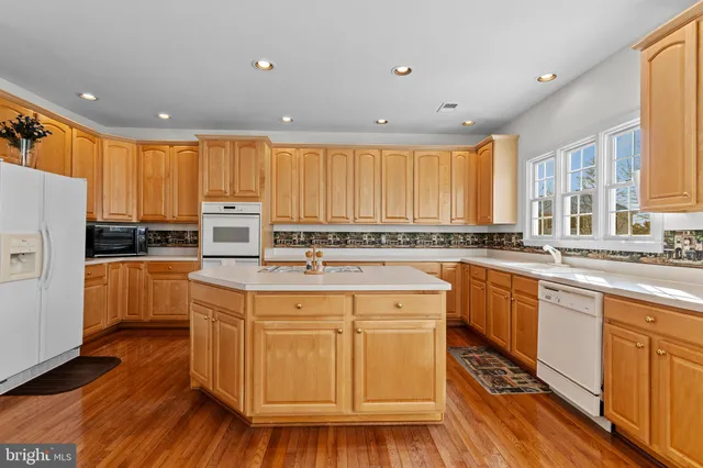 a kitchen with a refrigerator a sink and white cabinets