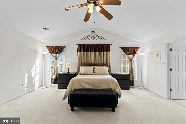 a bedroom with a bed and a ceiling fan