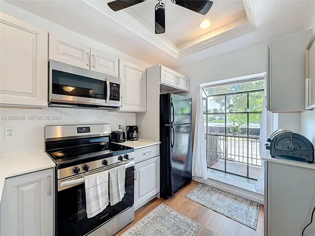 a kitchen with a sink a refrigerator and cabinets