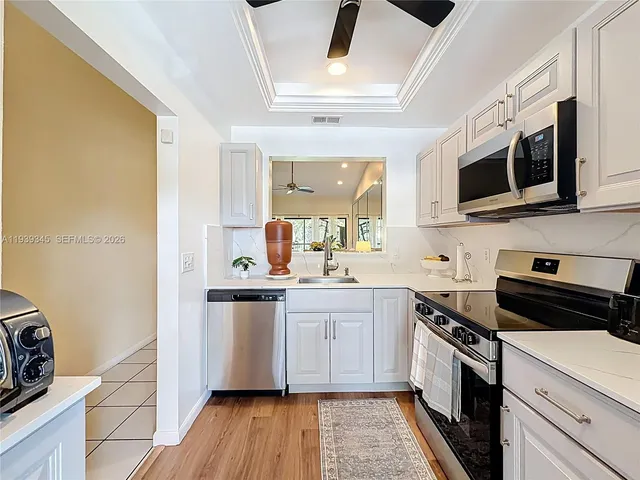 a kitchen with stainless steel appliances a refrigerator sink and microwave
