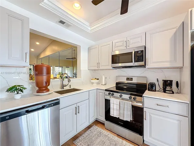 a kitchen with stainless steel appliances granite countertop a stove a sink and a refrigerator
