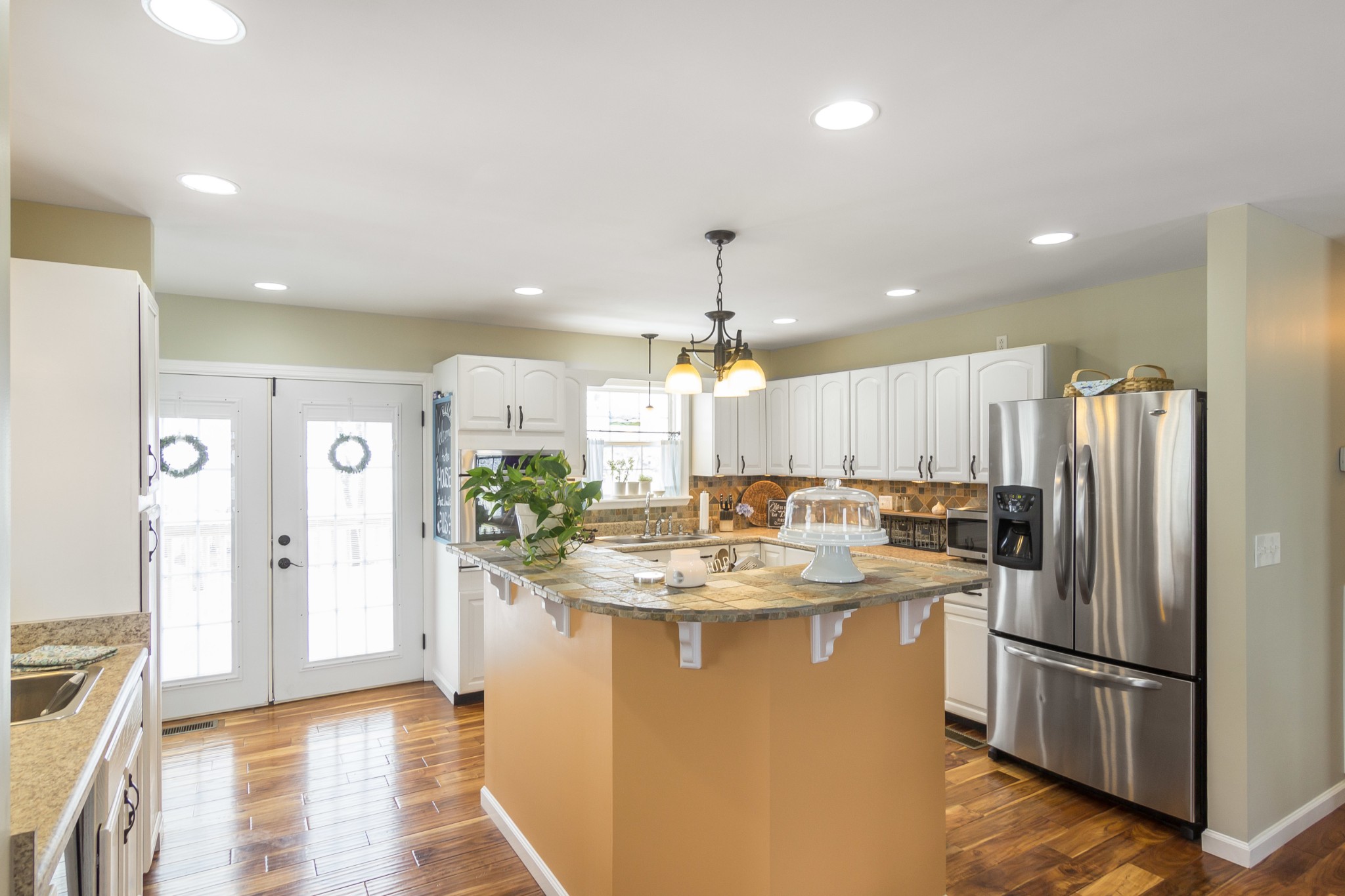 325 Osborne Road Watertown, TN 37184 - Photo 15 of 31 a kitchen with stainless steel appliances granite countertop a refrigerator a sink dishwasher and a dining table with wooden floor
