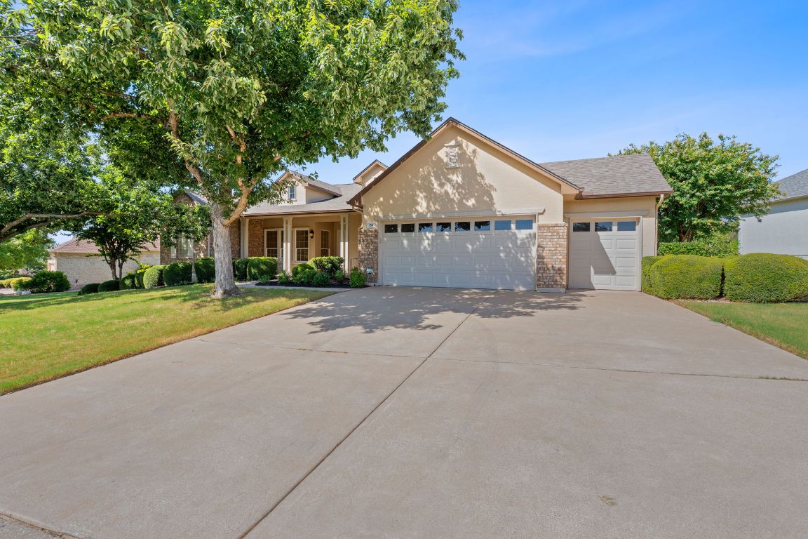 156 Trail Of The Flowers Georgetown, TX 78633 - Photo 1 of 1 View of front of property with a front yard, a garage, stucco siding, and driveway