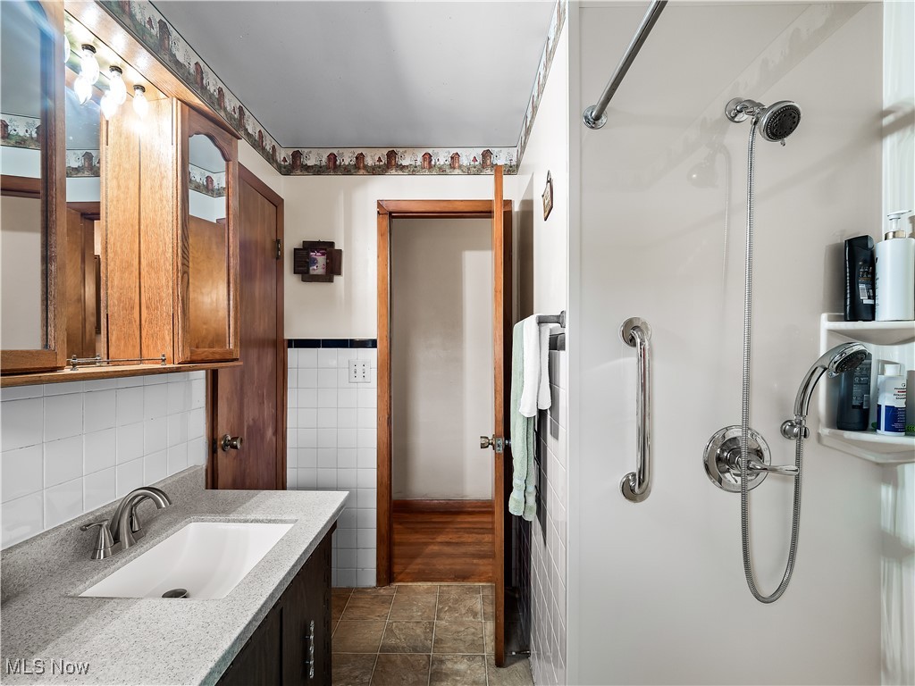 9049 Oberlin Road Elyria, OH 44035 - Photo 20 of 42 Full bathroom with a shower stall, vanity, and tile walls