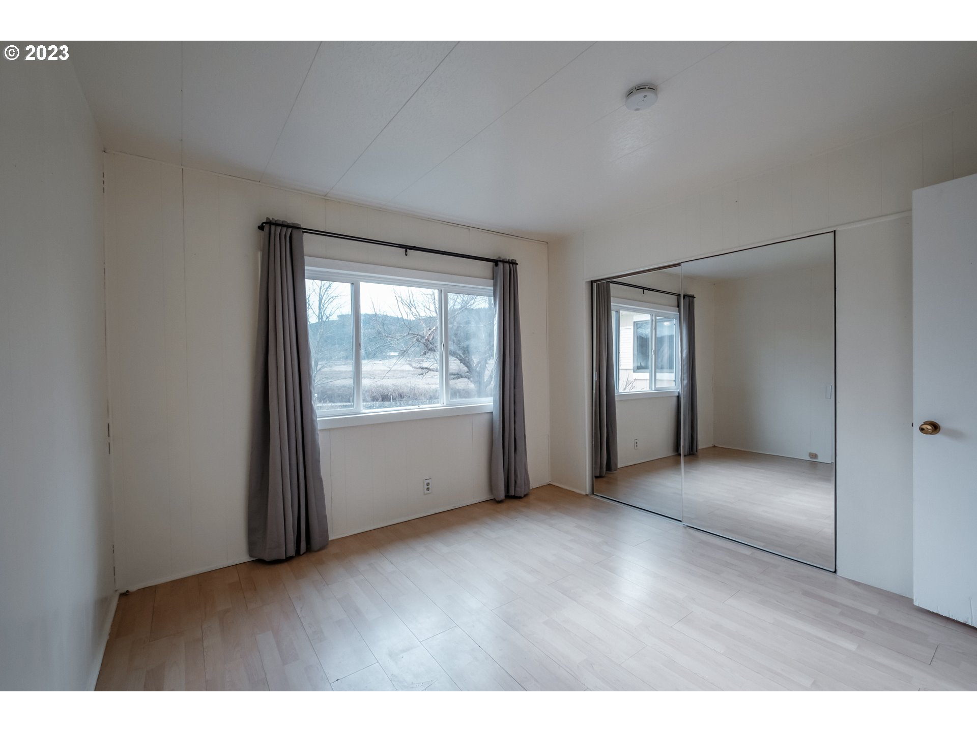 24333 Vaughn Road Veneta, OR 97487 - Photo 12 of 27 a view of an empty room with wooden floor and a window