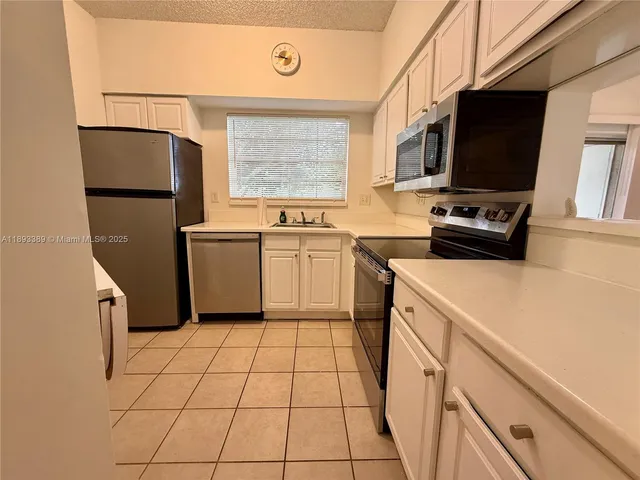 a kitchen with a stove a sink and a refrigerator