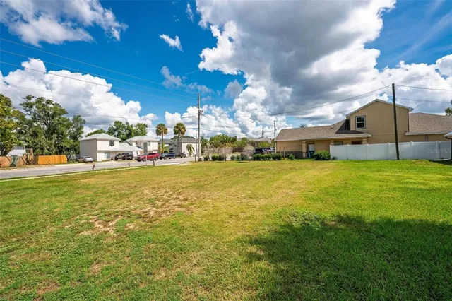a view of a fountain in front of a house with a big yard