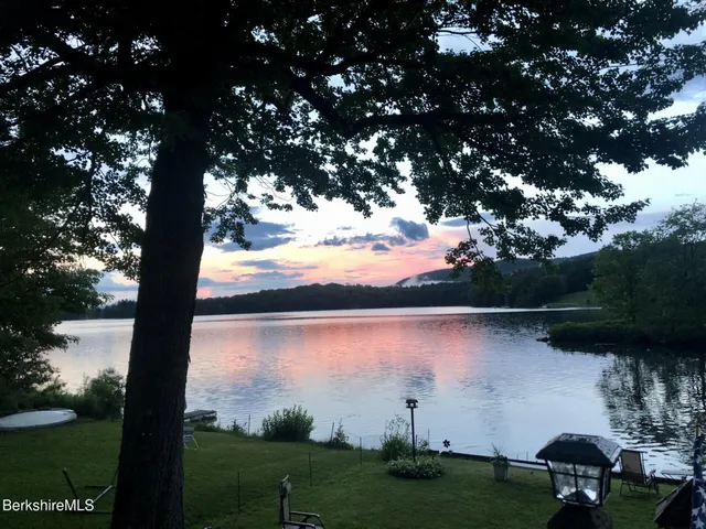 a large bedroom with a bed a couch and a view of kitchen