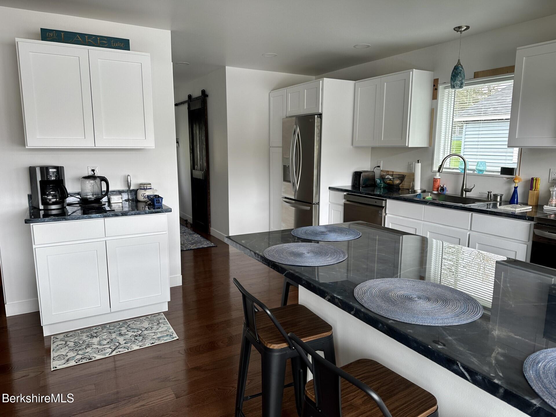 210 Shore Road Richmond, MA 01201 - Photo 9 of 22 a kitchen with stainless steel appliances granite countertop a sink a stove a refrigerator and white cabinets with wooden floor