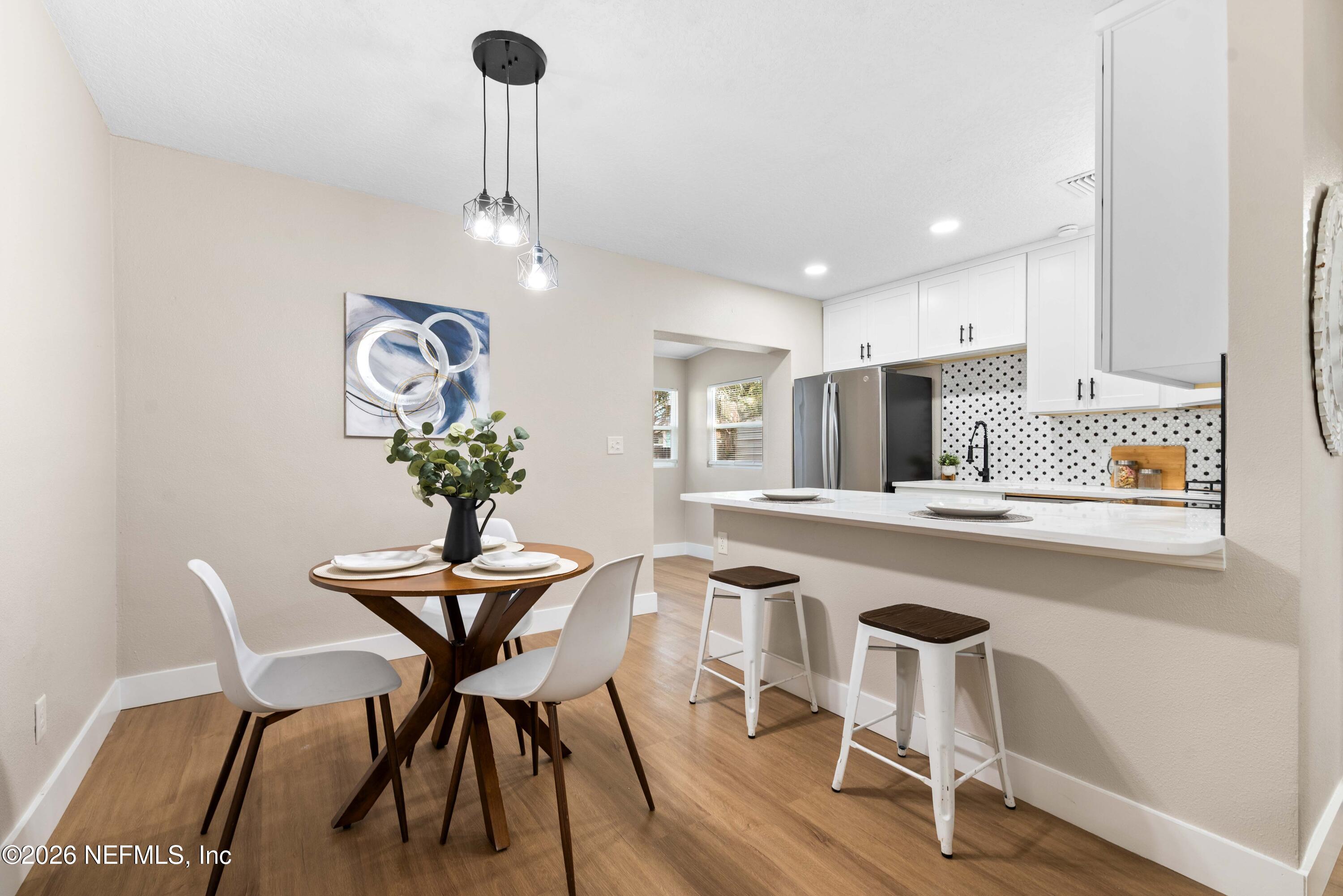 529 Sapelo Road Jacksonville, FL 32216 - Photo 11 of 31 a view of a dining room with furniture wooden floor and a chandelier