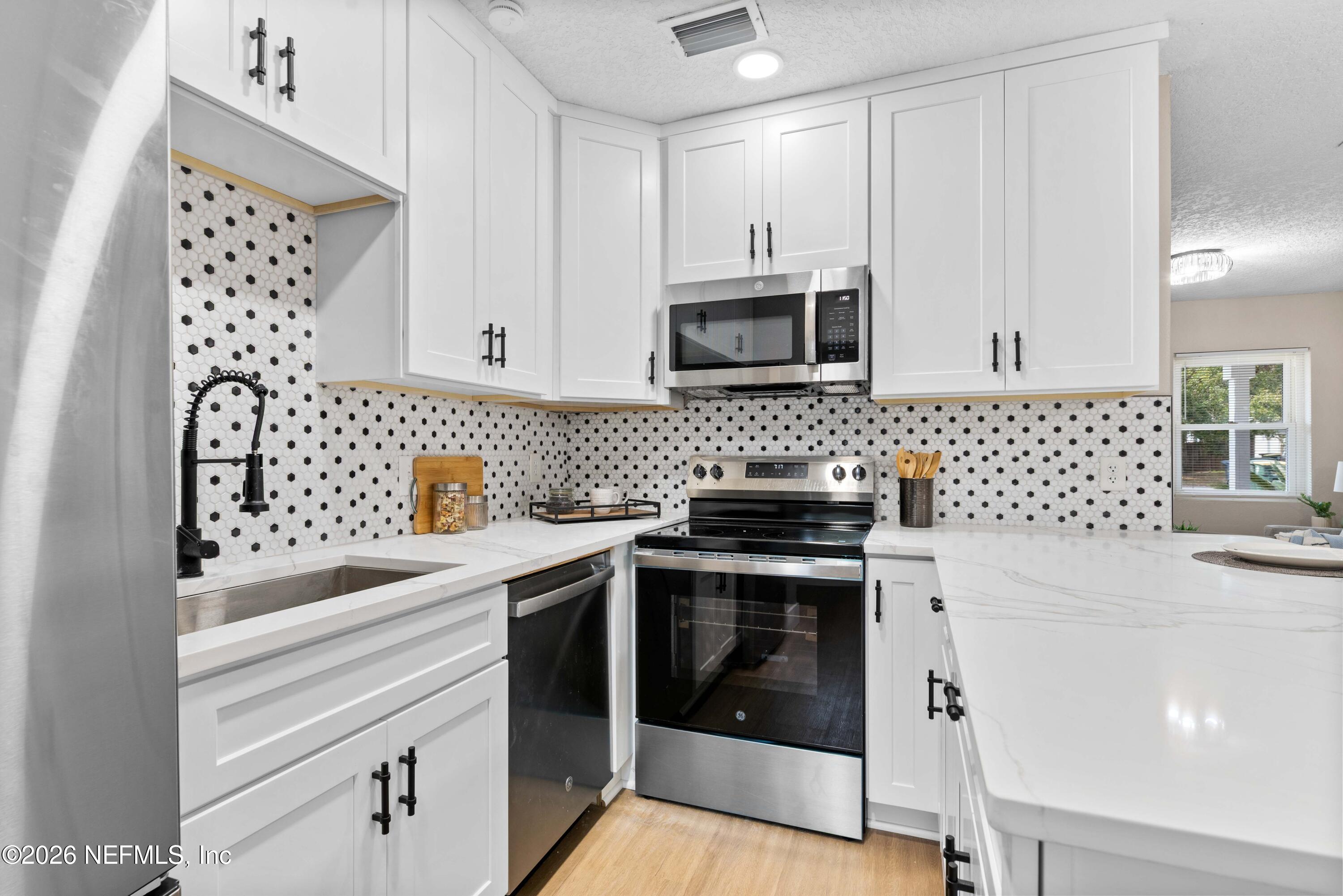 529 Sapelo Road Jacksonville, FL 32216 - Photo 13 of 31 a kitchen with a sink stove and microwave