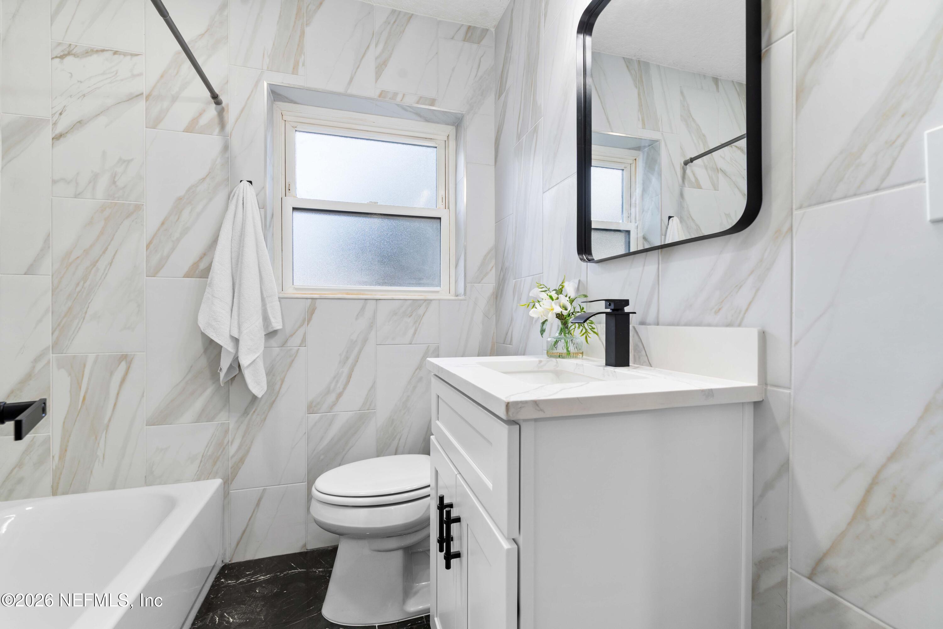 529 Sapelo Road Jacksonville, FL 32216 - Photo 22 of 31 a bathroom with a sink a toilet and bathtub