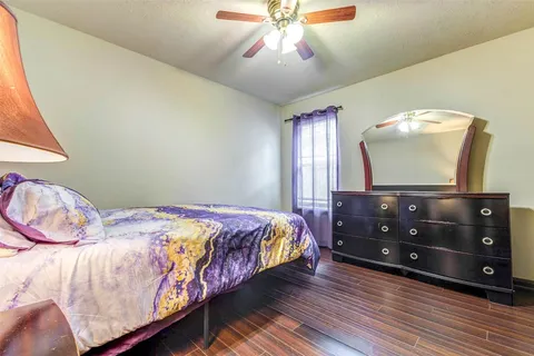 a bedroom with a bed and a flat tv screen on dresser
