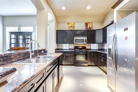 a kitchen with granite countertop a refrigerator and a sink