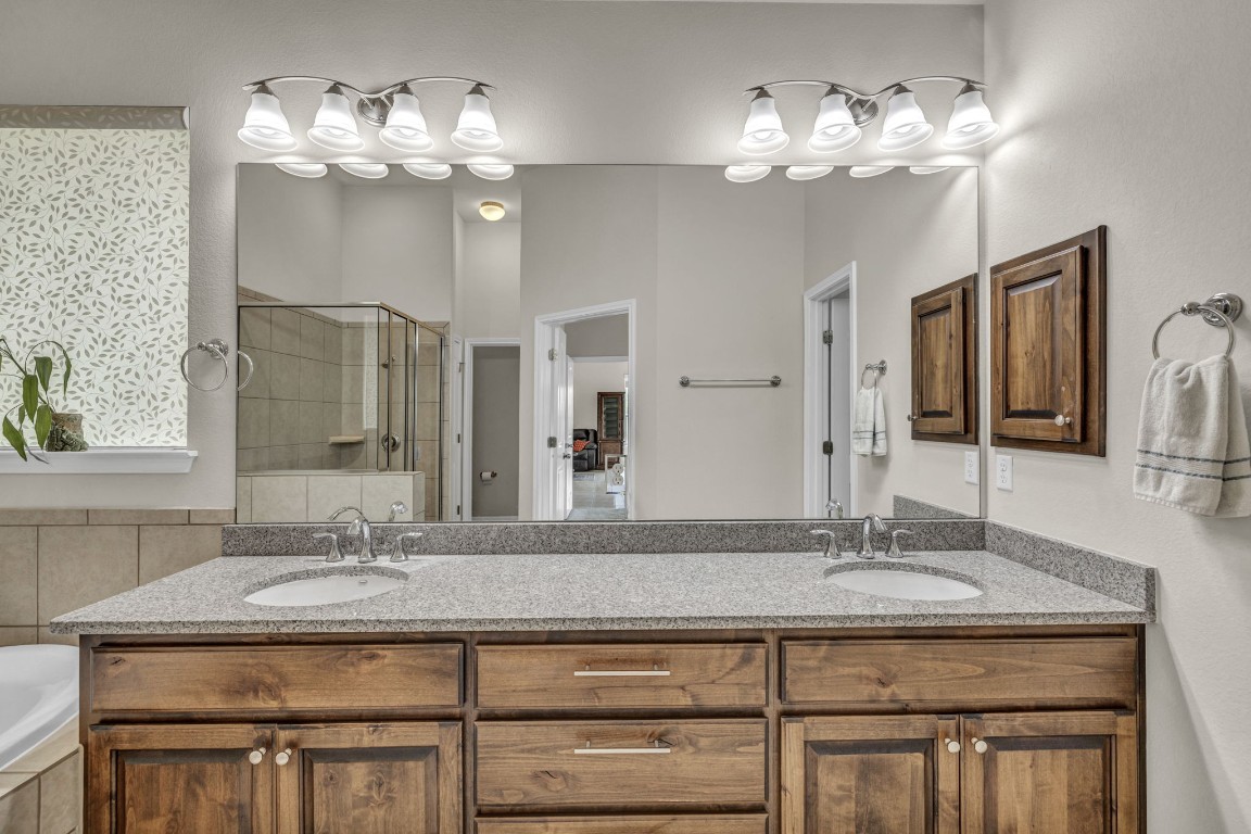 3821 Tordera Drive Austin, TX 78738 - Photo 25 of 30 a bathroom with a granite countertop sink a mirror and a vanity
