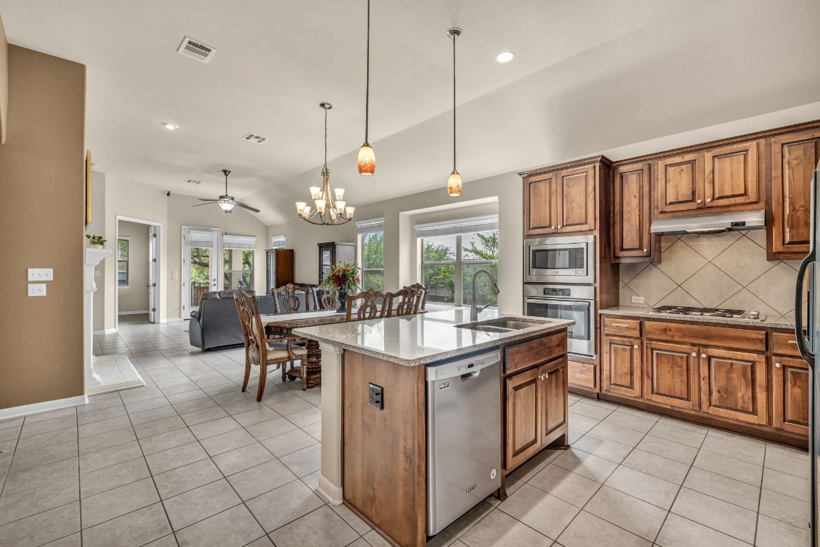 3821 Tordera Drive Austin, TX 78738 - Photo 7 of 30 a kitchen with stainless steel appliances granite countertop a stove a sink and a refrigerator